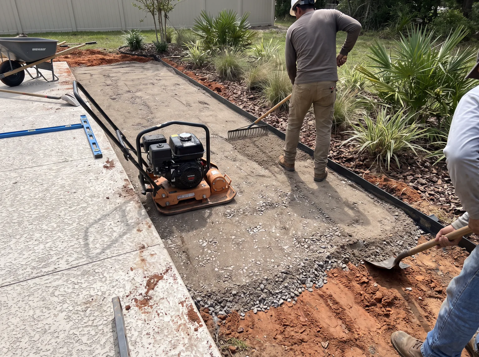 Backyard turf base transition beside a patio or landscape edge.